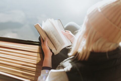 woman sitting while holding a book