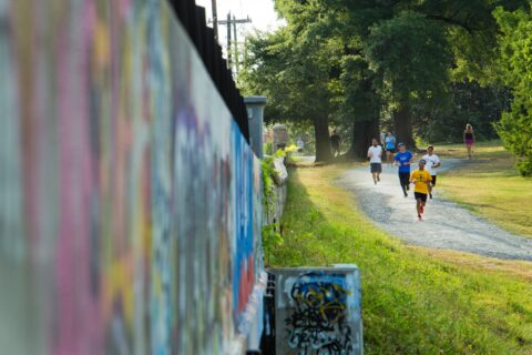people walking and jogging in a park in the summer