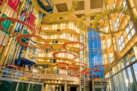 inside of building with colorful sculpture hanging from the ceiling