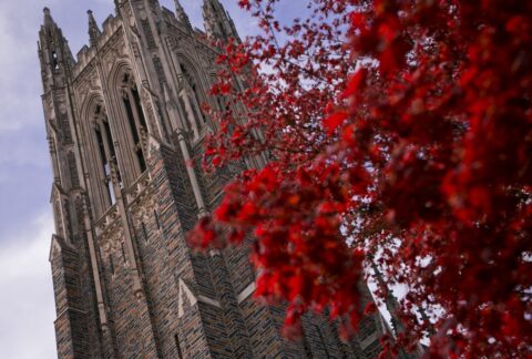 Duke Chapel framed with a tree with red blossoms