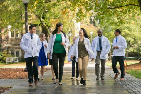 medical students walking and talking under trees