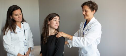 a doctor examining a patient for a rotator cuff injury while another physician watches