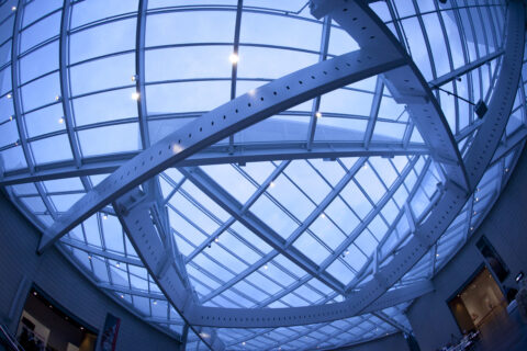 interior of a building during the evening lookup up at a skylight with crossing beams that form a pentagon