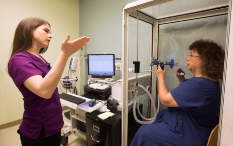 nurse talking with patient getting ready to perform a pulmonary function test
