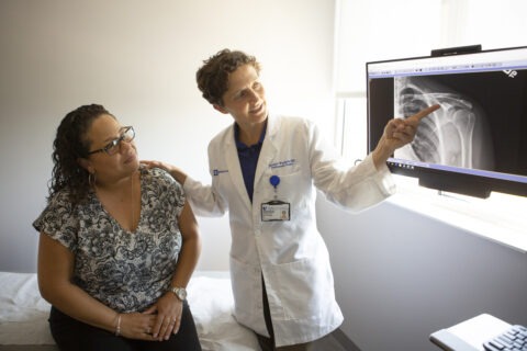 doctor and patient reviewing an X-ray of the patient's shoulder